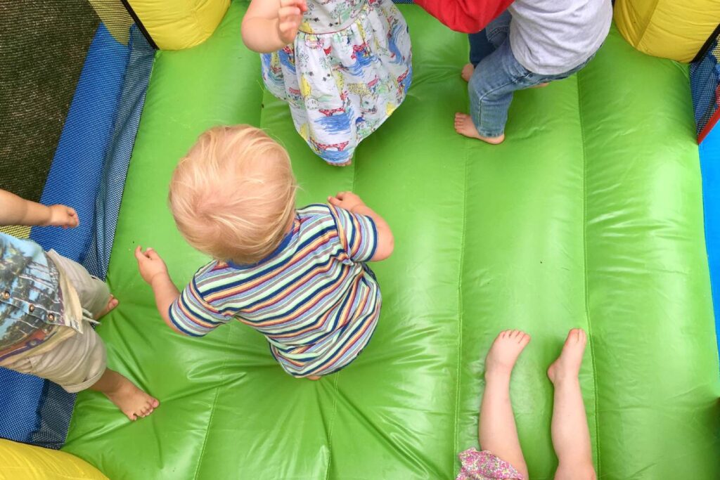 friends playing on bouncy castle at playground 1 scaled e1701776517679 1